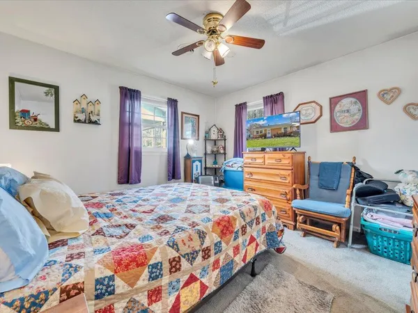 a bedroom with bed and paintings on the wall