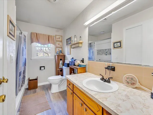 a bathroom with a granite countertop sink mirror vanity and toilet