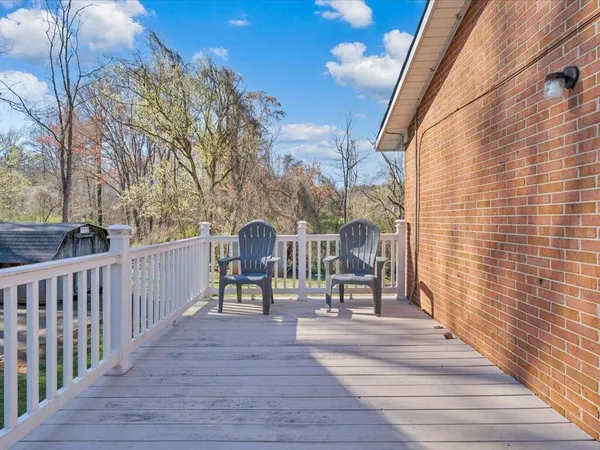 a view of a deck with chairs and wooden fence