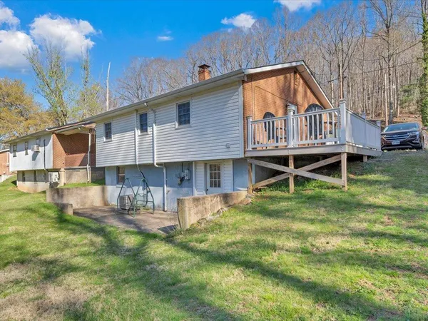 a backyard of a house with wooden deck and barbeque oven