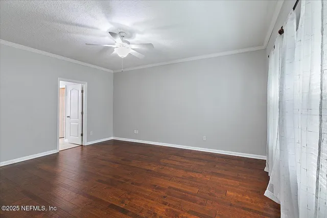 a view of an empty room with wooden floor