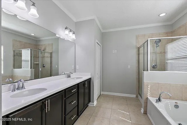 a bathroom with a double vanity sink a large mirror and a bathtub
