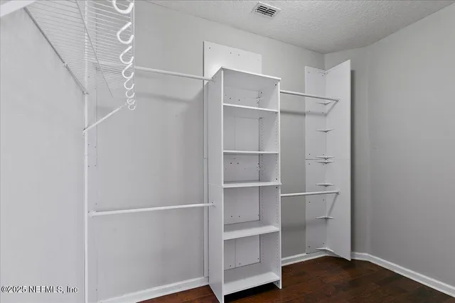 a view of walk in closet with empty racks