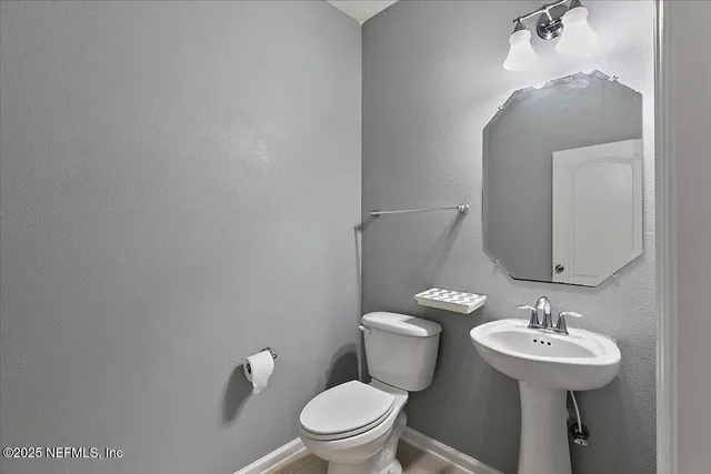 a bathroom with a toilet a sink and mirror