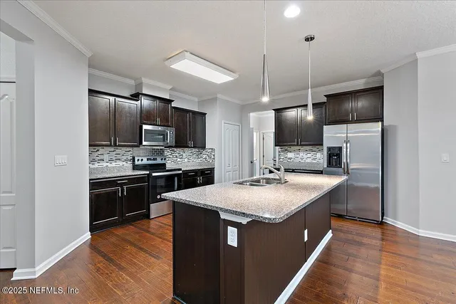 a kitchen with kitchen island a sink stainless steel appliances and refrigerator