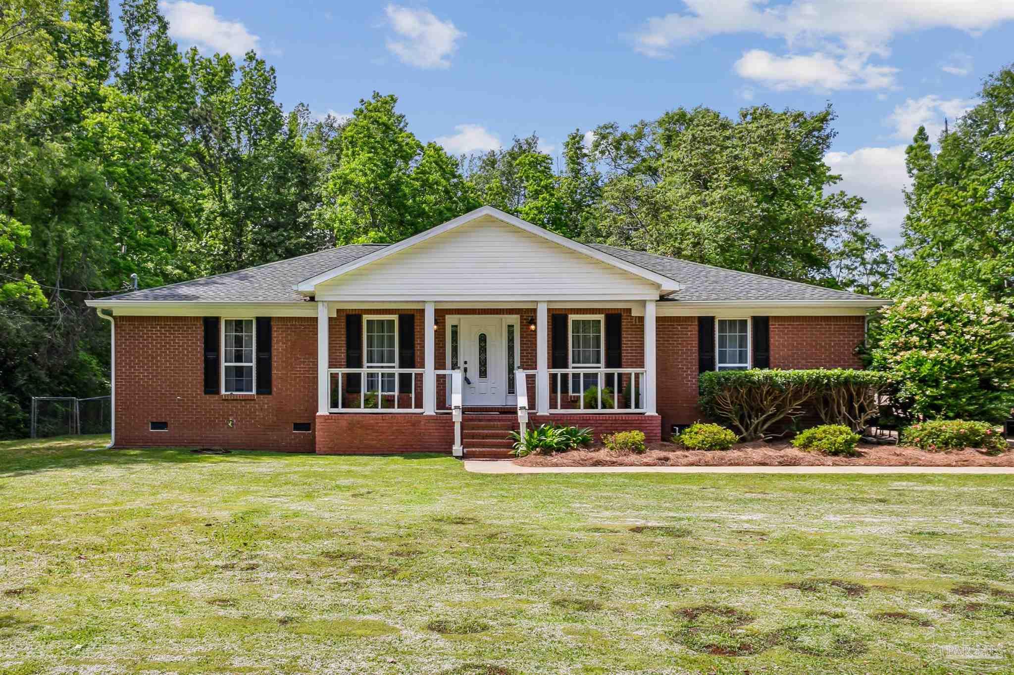 7260 Morrell Road Milton, FL 32583 - Photo 1 of 33 a front view of a house with garden and porch