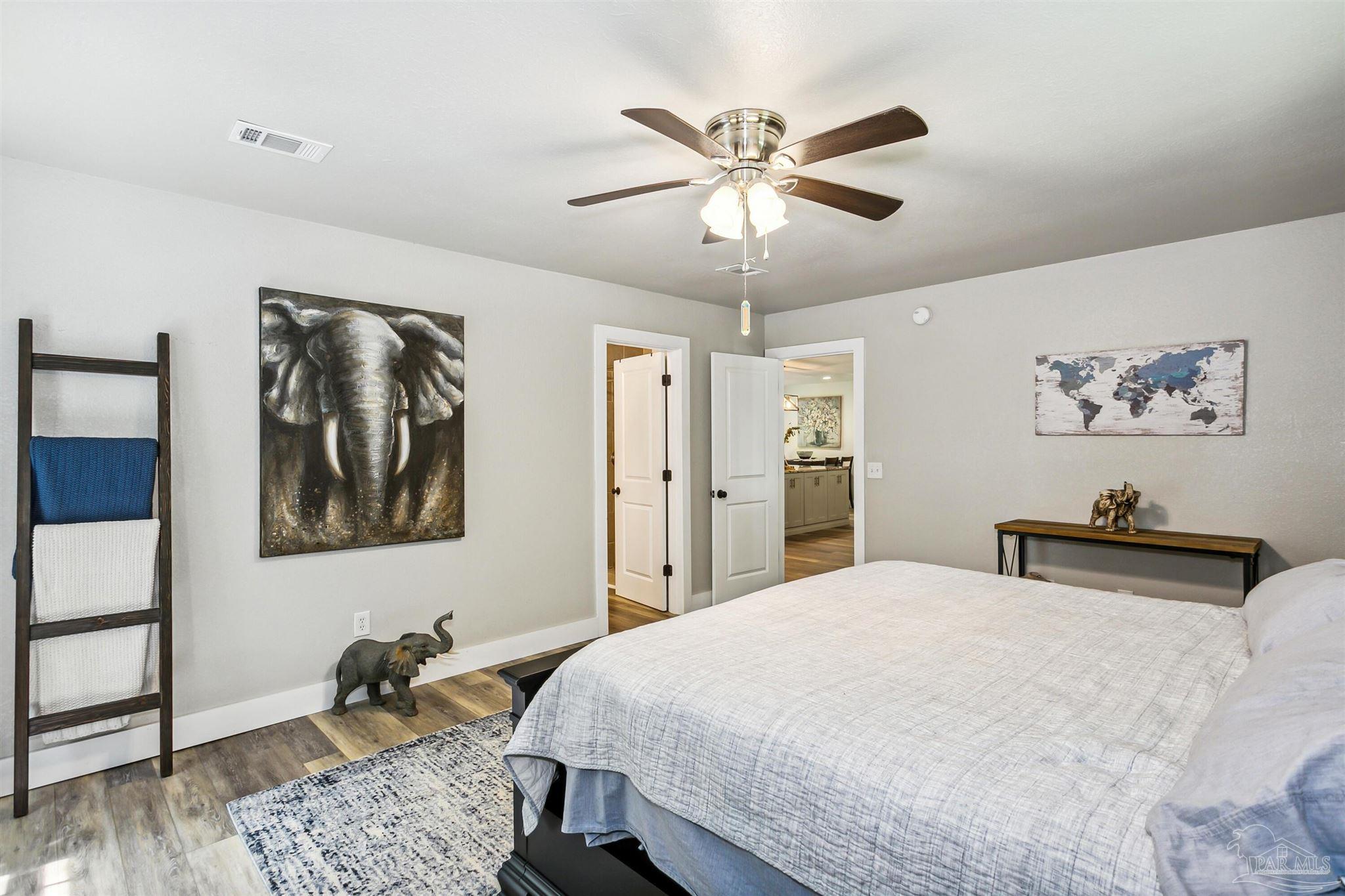 7260 Morrell Road Milton, FL 32583 - Photo 15 of 33 a bedroom with a large bed and a chandelier