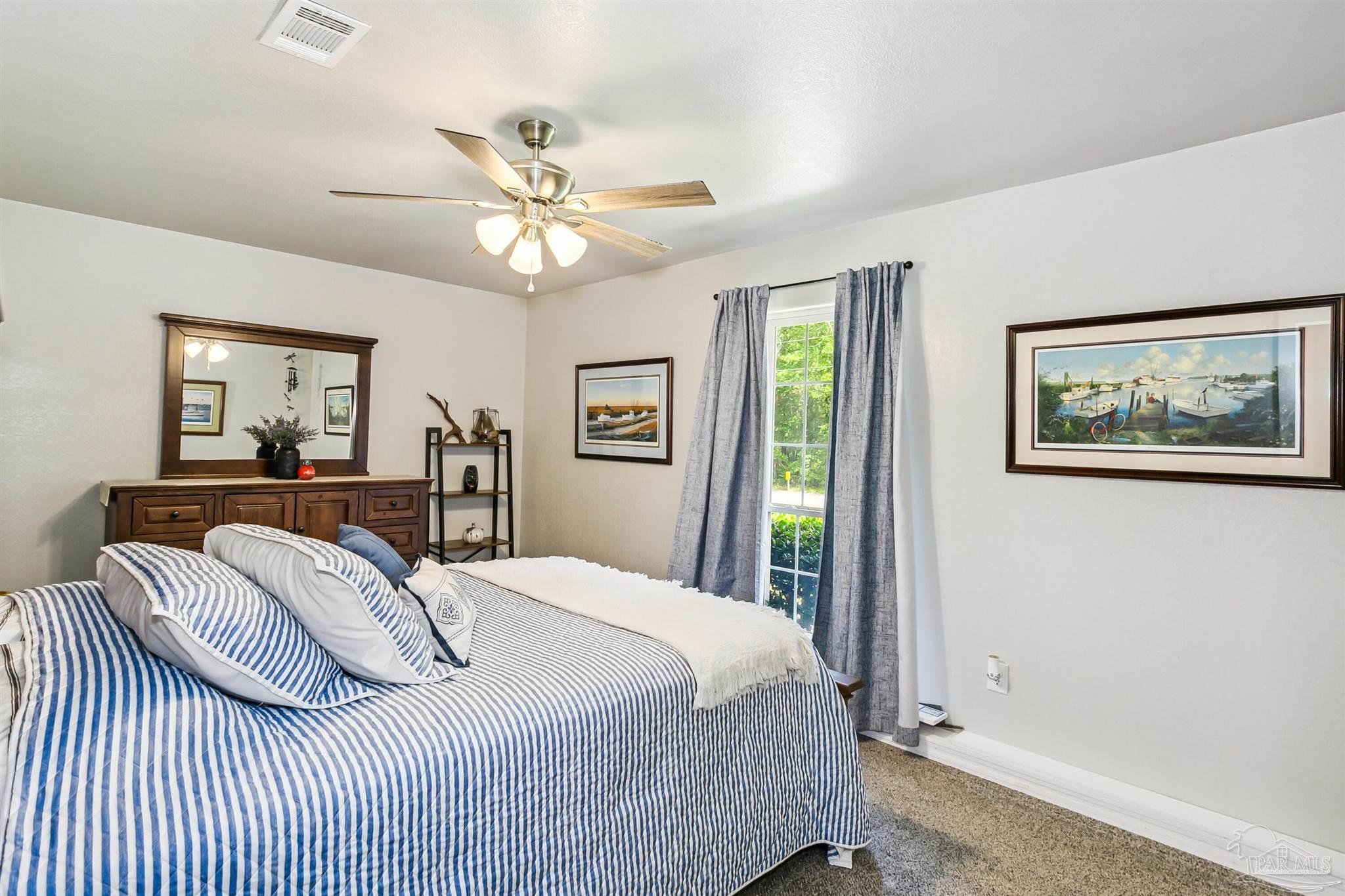 7260 Morrell Road Milton, FL 32583 - Photo 19 of 33 a bedroom with a large bed and a chandelier