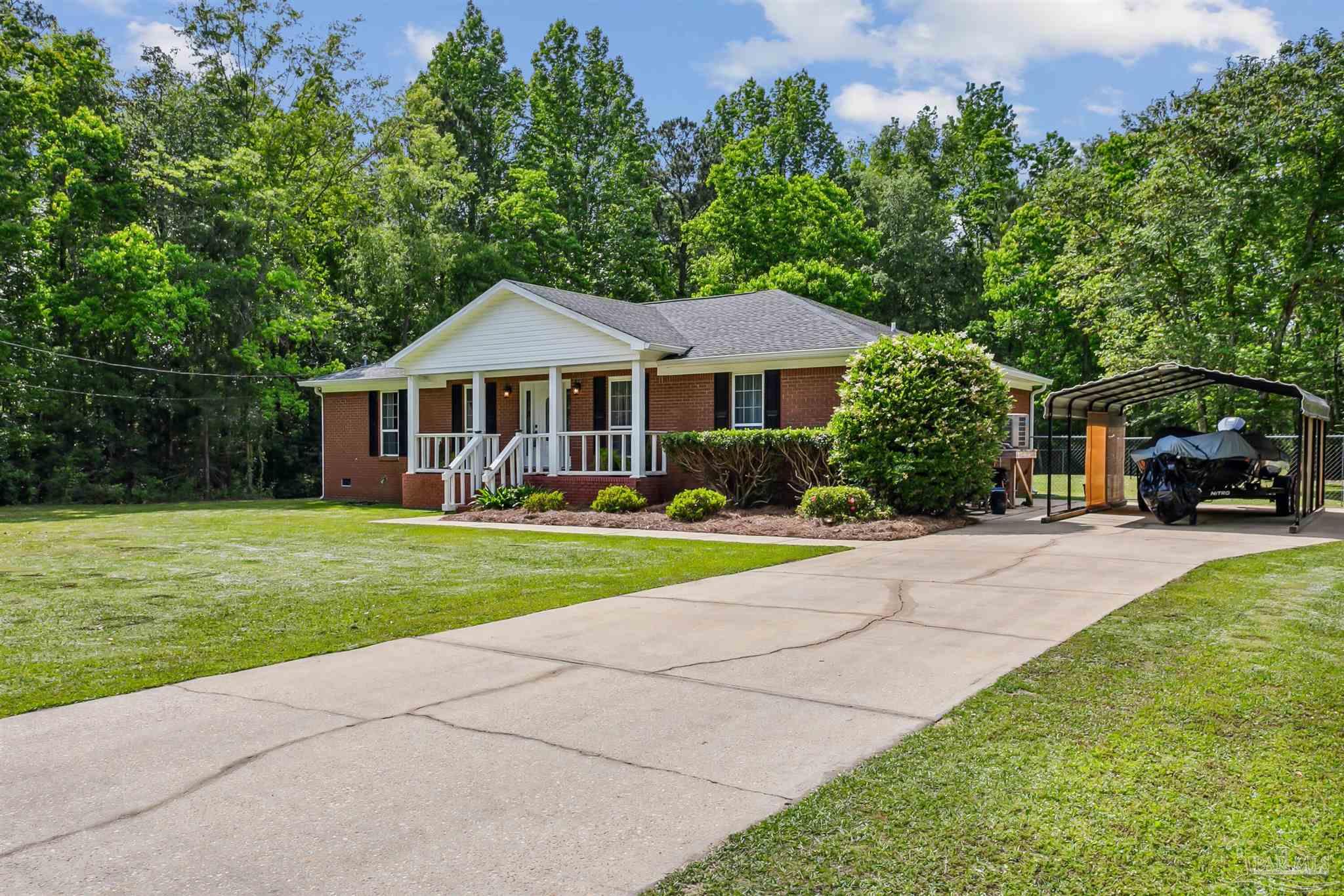 7260 Morrell Road Milton, FL 32583 - Photo 3 of 33 a front view of a house with a yard table and chairs