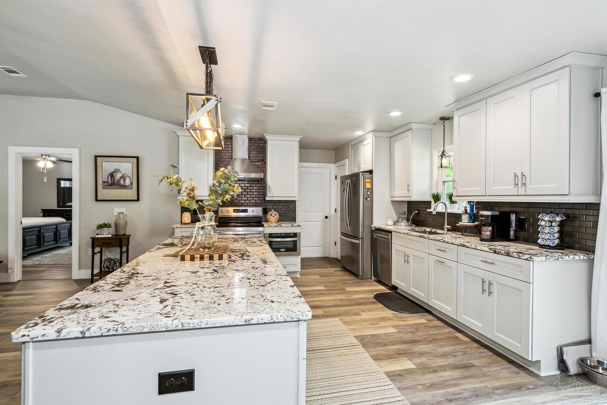 7260 Morrell Road Milton, FL 32583 - Photo 5 of 33 a large kitchen with kitchen island a sink stove and refrigerator