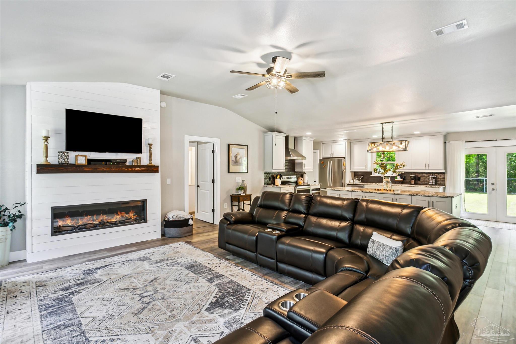 7260 Morrell Road Milton, FL 32583 - Photo 6 of 33 a living room with furniture a flat screen tv and a fireplace