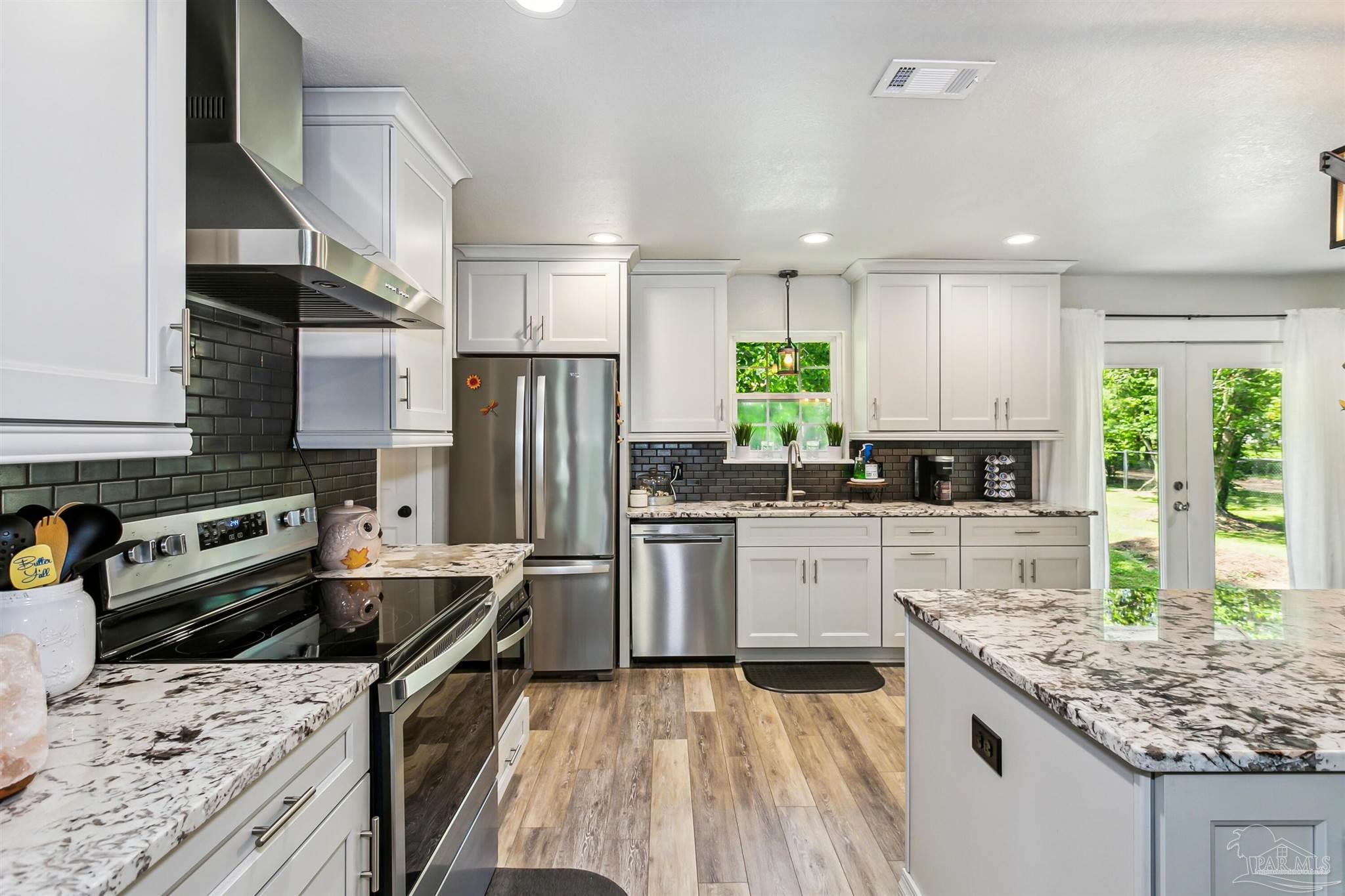7260 Morrell Road Milton, FL 32583 - Photo 8 of 33 a kitchen with a stove a sink a microwave a refrigerator and cabinets