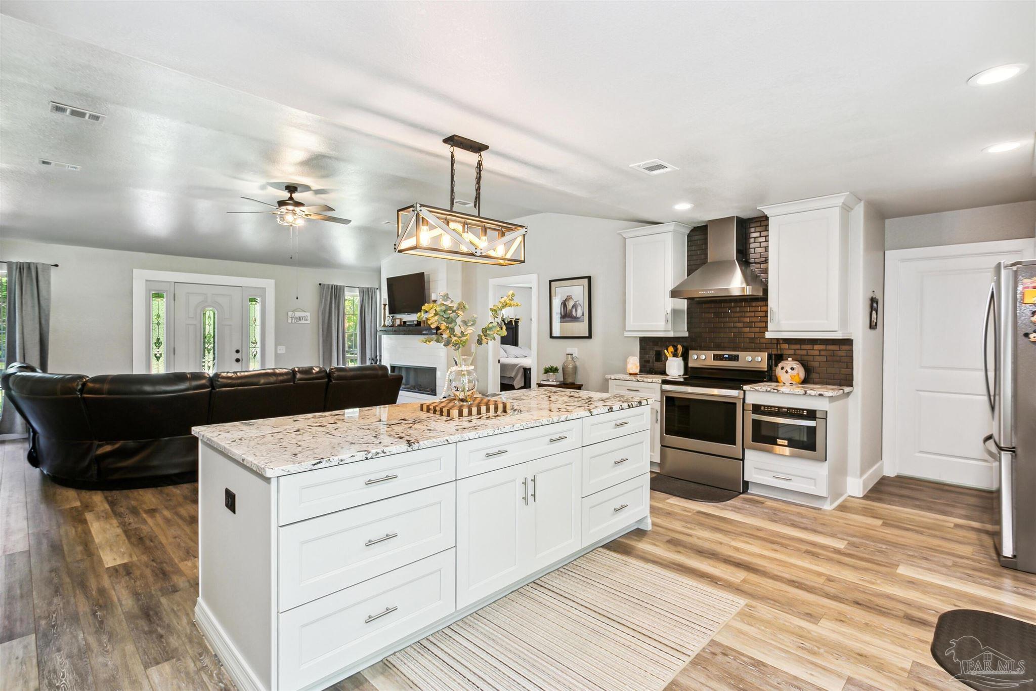7260 Morrell Road Milton, FL 32583 - Photo 9 of 33 a kitchen with a stove a sink a refrigerator and cabinets