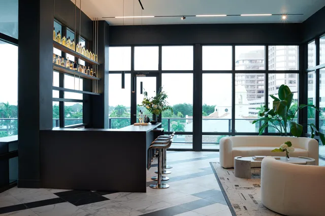 a living room with furniture tv and a floor to ceiling window