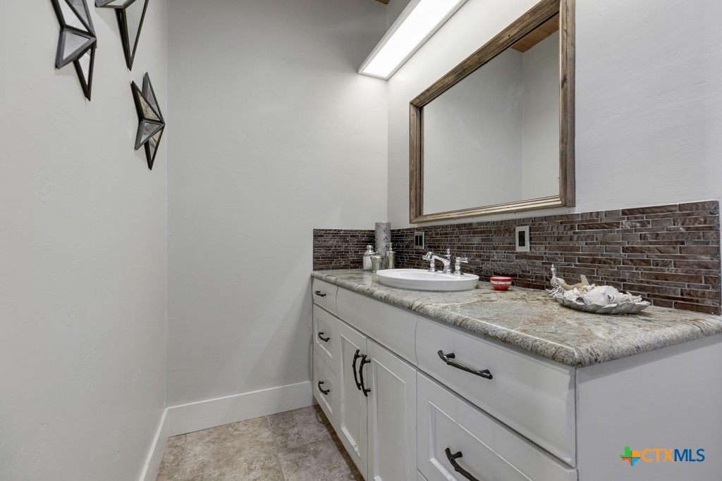 1440 West Klein Road New Braunfels, TX 78130 - Photo 23 of 42 a bathroom with a granite countertop sink and a mirror