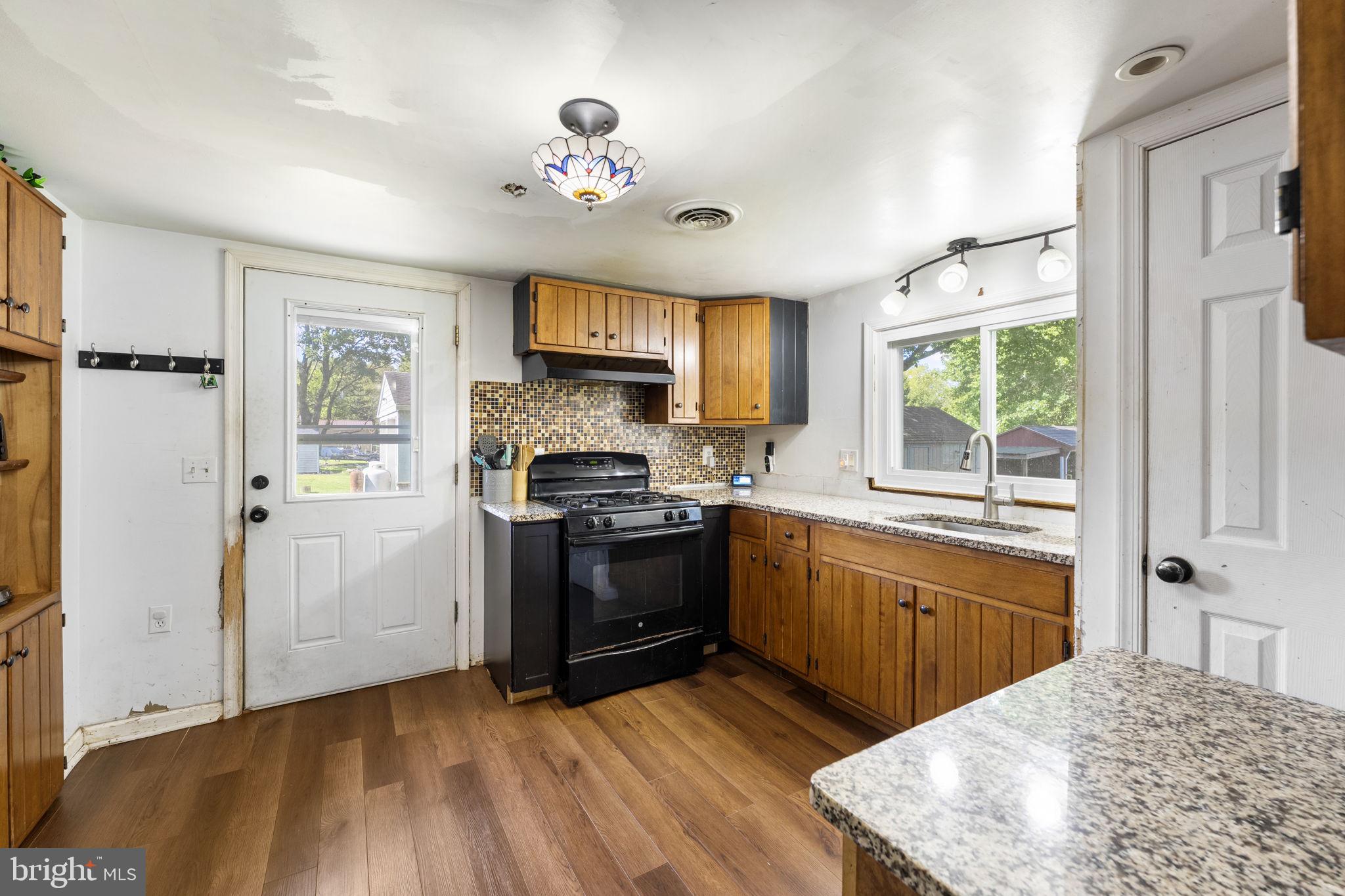 5087 Wheatleys Pond Road Smyrna, DE 19977 - Photo 7 of 36 a kitchen with a stove a sink and a refrigerator
