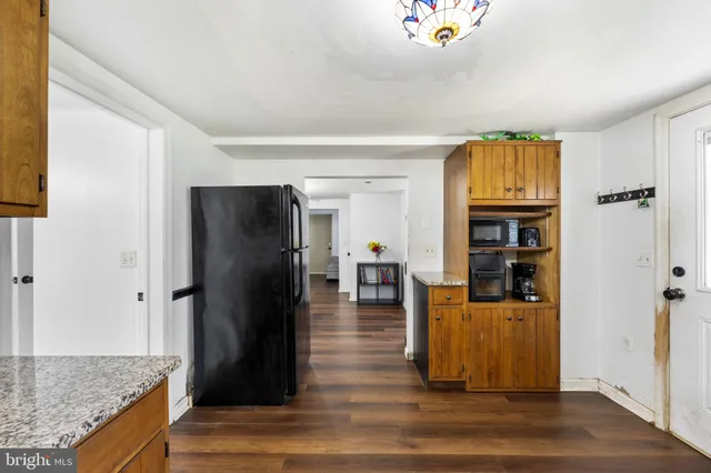a living room with stainless steel appliances kitchen island granite countertop furniture and a refrigerator
