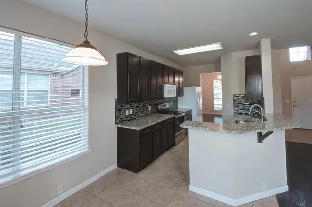 a large kitchen with kitchen island a sink stainless steel appliances and cabinets