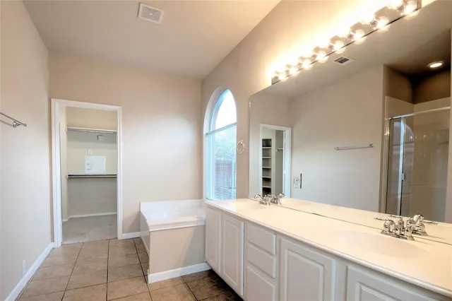 a bathroom with a double vanity sink and a mirror