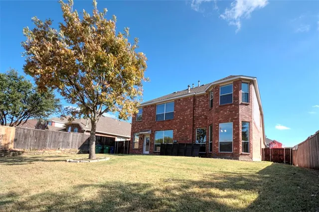 a tall brick building with a trees in front of it