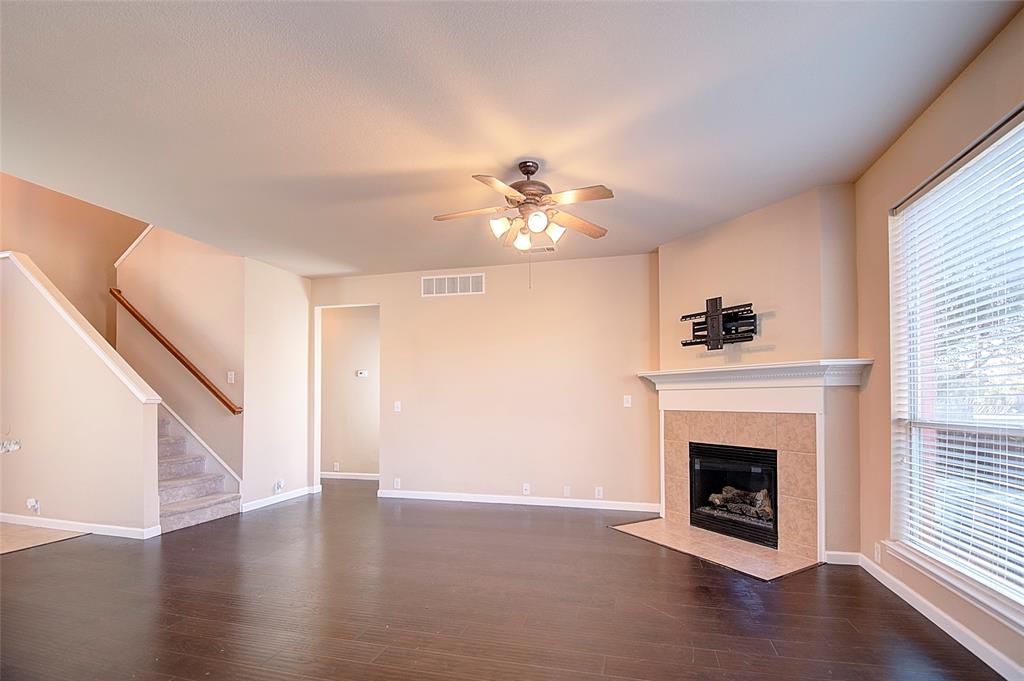 2012 Trinity Lane McKinney, TX 75072 - Photo 9 of 32 a view of a livingroom with a fireplace a ceiling fan and wooden floor