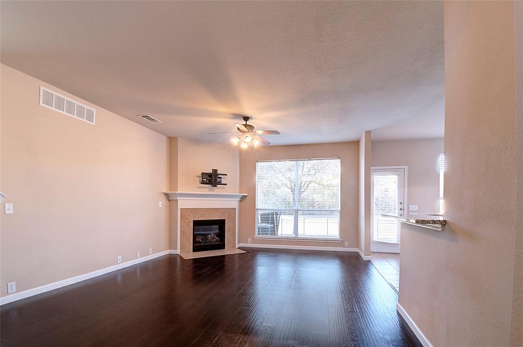 2012 Trinity Lane McKinney, TX 75072 - Photo 10 of 32 an empty room with wooden floor fireplace and windows