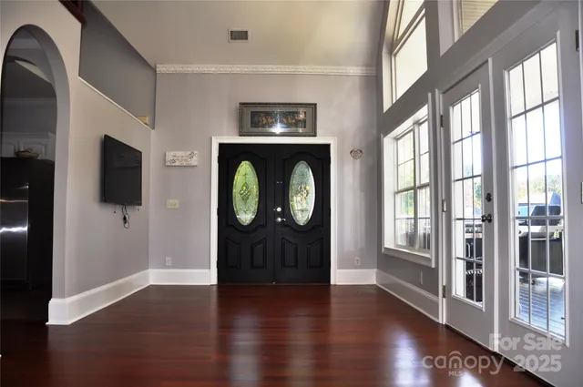 a view of an entryway with wooden floor mirror and a window