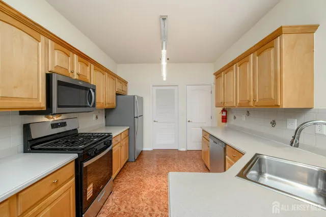 a kitchen with stainless steel appliances a stove sink microwave and cabinets