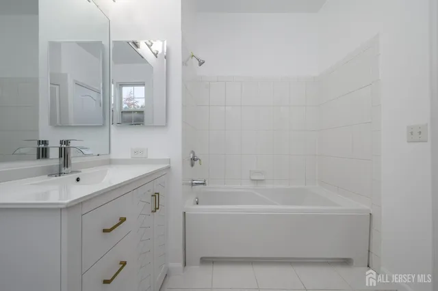 a bathroom with a bathtub sink vanity and mirror