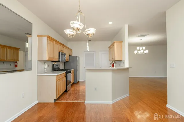 a large kitchen with kitchen island a sink stainless steel appliances and cabinets