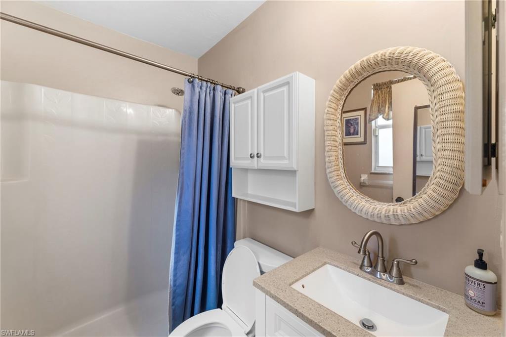 1700 42nd Terrace Southwest Naples, FL 34116 - Photo 15 of 27 Bathroom with toilet, a shower with shower curtain, and vanity