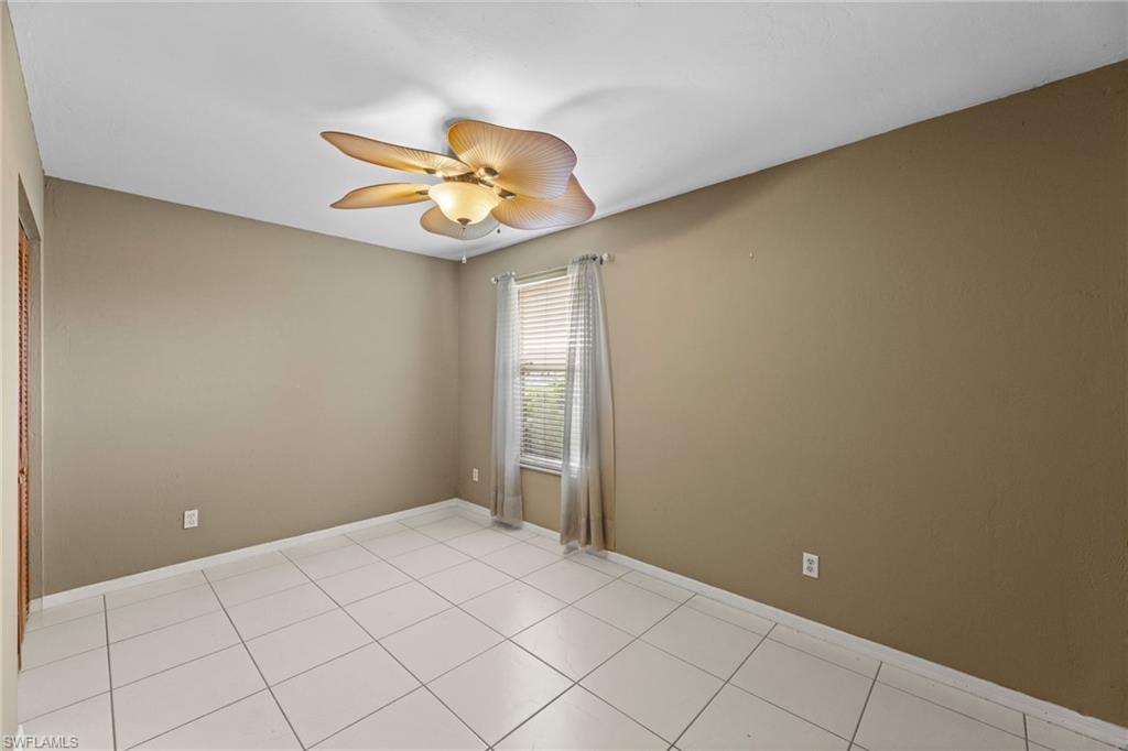 1700 42nd Terrace Southwest Naples, FL 34116 - Photo 17 of 27 Empty room with light tile patterned floors, ceiling fan, and baseboards