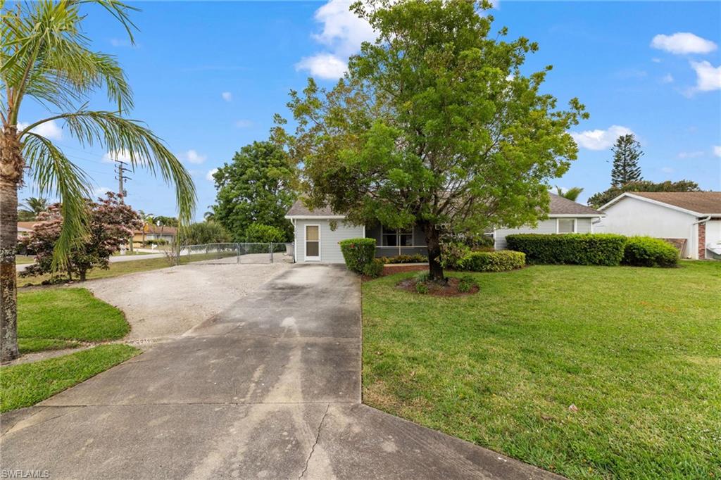 1700 42nd Terrace Southwest Naples, FL 34116 - Photo 2 of 27 View of front of home featuring driveway, a front lawn, and fence