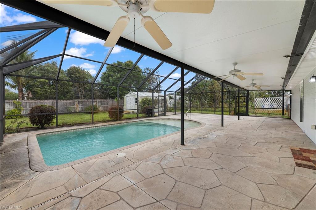 1700 42nd Terrace Southwest Naples, FL 34116 - Photo 22 of 27 View of swimming pool featuring a storage shed, a fenced backyard, a patio area, and an outdoor structure