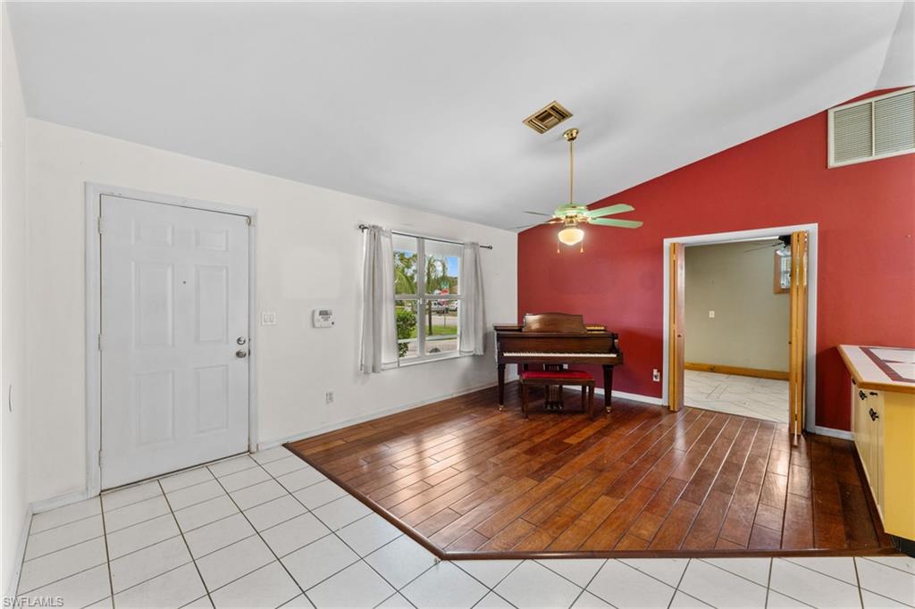 1700 42nd Terrace Southwest Naples, FL 34116 - Photo 4 of 27 Foyer featuring vaulted ceiling, light wood-style floors, visible vents, and a ceiling fan