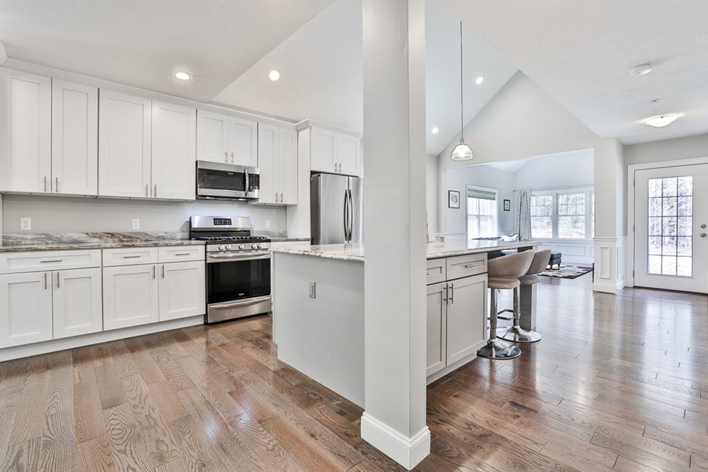 2 Trail Ridge Way, Unit D Harvard, MA 01451 - Photo 11 of 31 a kitchen with stainless steel appliances granite countertop white cabinets a sink a stove a refrigerator and microwave