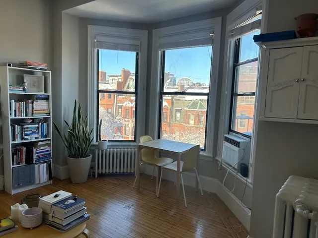a room with wooden floor and a book shelf