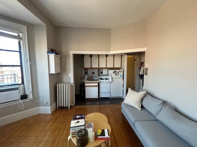 a living room with furniture and kitchen view