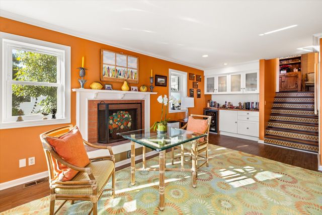 a living room with a fireplace dining table and a large window