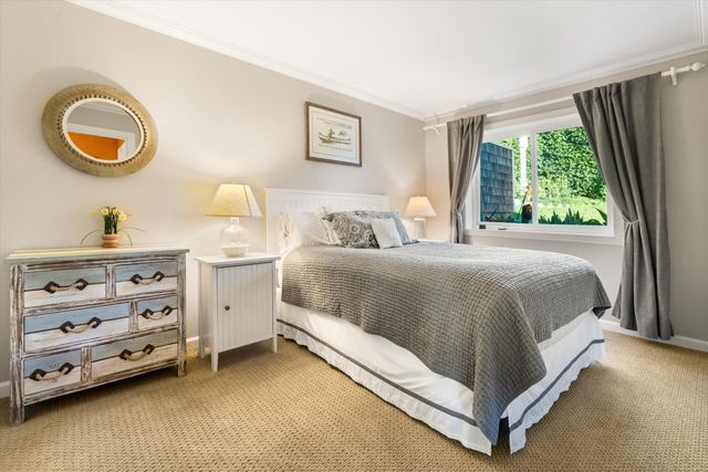 a bedroom with a bed and a dresser next to a window