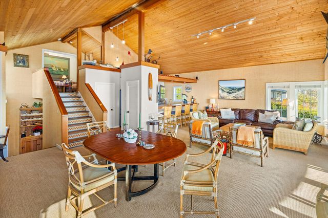 a living room with furniture a rug and a floor to ceiling window