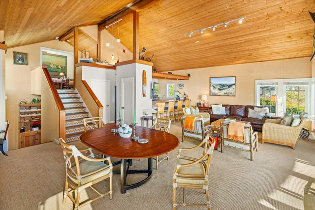 a living room with furniture a rug and a floor to ceiling window