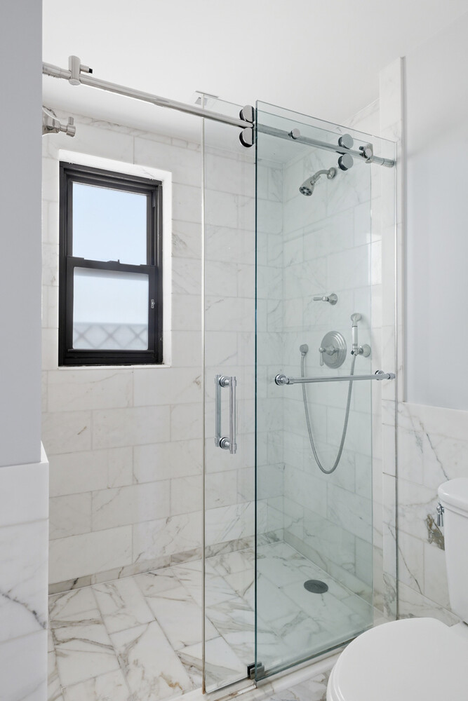 110 East 36th Street, Unit 12B Manhattan, NY 10016 - Photo 11 of 16 a bathroom with a shower a toilet and sink
