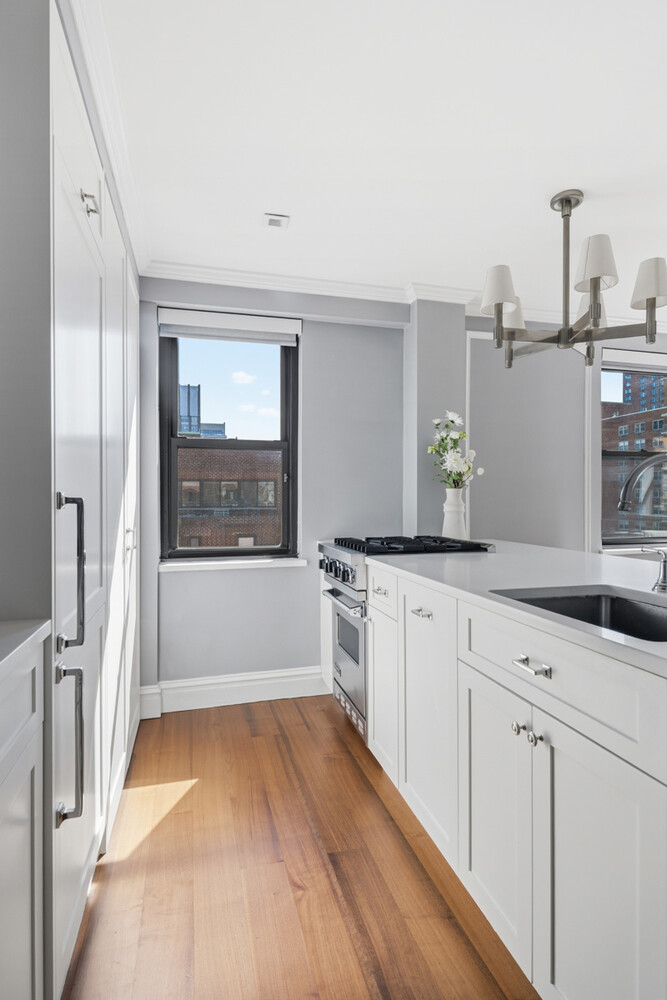 110 East 36th Street, Unit 12B Manhattan, NY 10016 - Photo 3 of 16 a kitchen with white cabinets and window