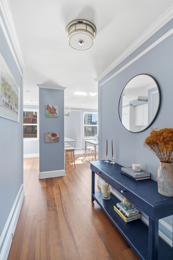 110 East 36th Street, Unit 12B Manhattan, NY 10016 - Photo 4 of 16 a room with wooden floor and a chandelier