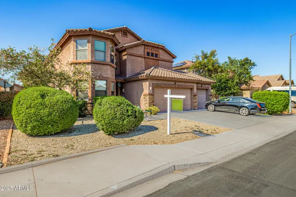 a front view of a house with a garden and plants