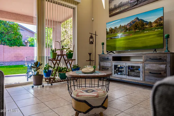 a living room with patio furniture and a flat screen tv