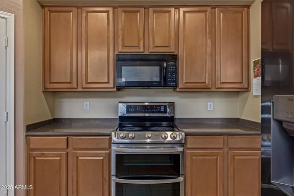 a kitchen with granite countertop wooden cabinets and a stove top oven