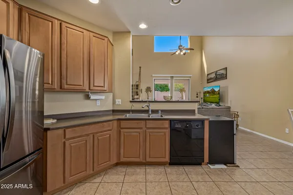 a kitchen with stainless steel appliances granite countertop a sink and a refrigerator