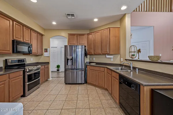 a kitchen with stainless steel appliances granite countertop a sink stove and refrigerator